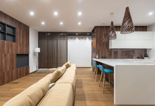 Beige Pendelleuchten hängen elegant über einem Esstisch und schaffen eine warme, einladende Atmosphäre in einem modernen Wohnraum.